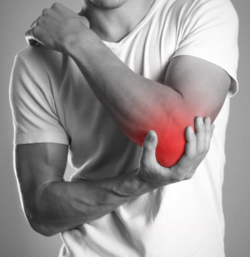 Man holding painful elbow joint highlighting need for Shoulder & Elbow Surgery in Gurgaon by Dr. (Prof.) Ravi Sauhta